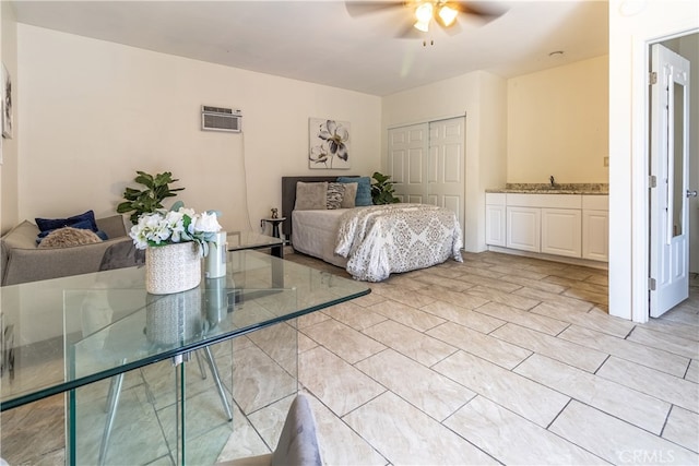 bedroom with ceiling fan, a closet, a wall mounted AC, ensuite bath, and light tile floors