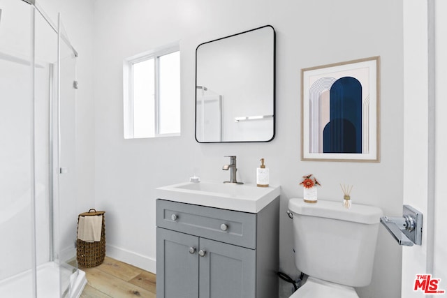 bathroom featuring oversized vanity, hardwood / wood-style flooring, toilet, and walk in shower