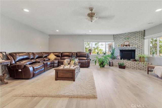 living room with ceiling fan, a healthy amount of sunlight, and light wood-type flooring