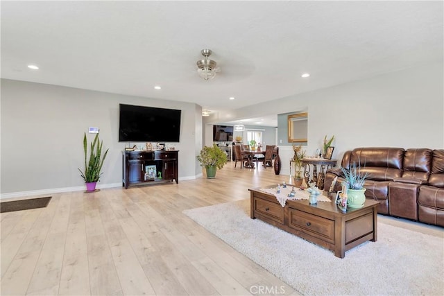 living room with ceiling fan and light hardwood / wood-style floors