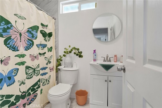 bathroom featuring tile patterned flooring, vanity, toilet, and walk in shower