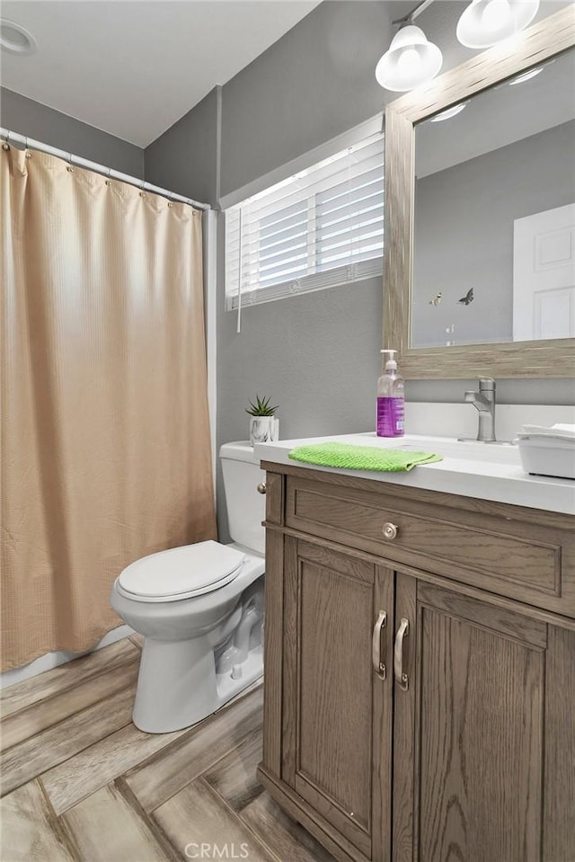 bathroom featuring wood-type flooring, vanity, toilet, and a shower with curtain