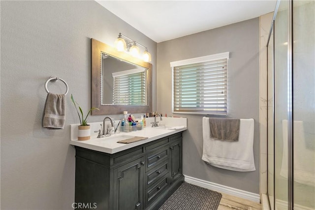 bathroom with hardwood / wood-style floors, vanity, and a shower with shower door