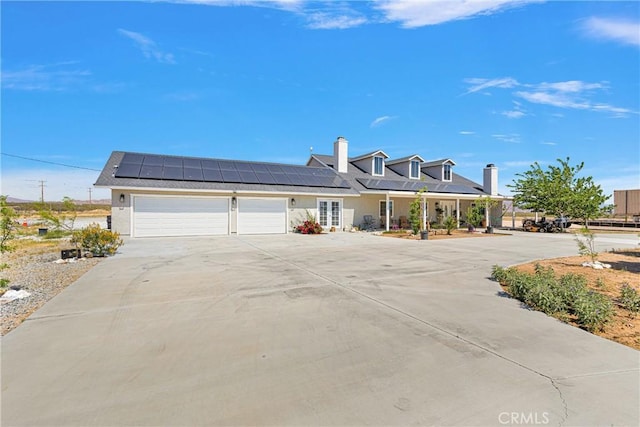 view of front of property with a garage and solar panels