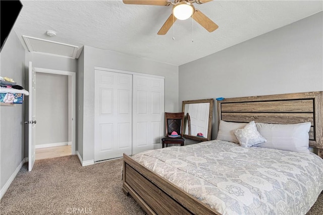 bedroom with a textured ceiling, ceiling fan, light carpet, and a closet