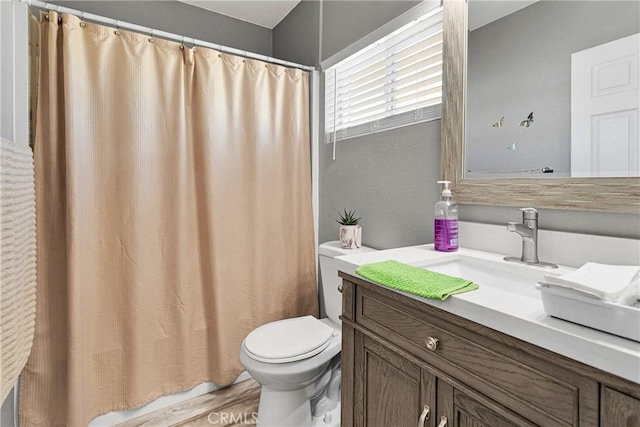 full bathroom with hardwood / wood-style flooring, shower / tub combo with curtain, vanity, and toilet