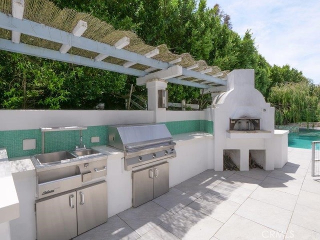 view of patio with area for grilling, exterior kitchen, and sink