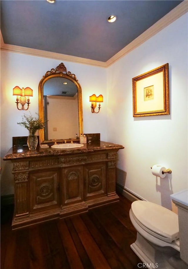 bathroom featuring wood-type flooring, toilet, vanity, and crown molding