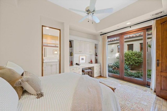 bedroom featuring built in desk, ceiling fan, access to outside, light hardwood / wood-style flooring, and ensuite bath