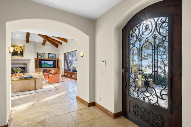 foyer entrance featuring beamed ceiling and ceiling fan