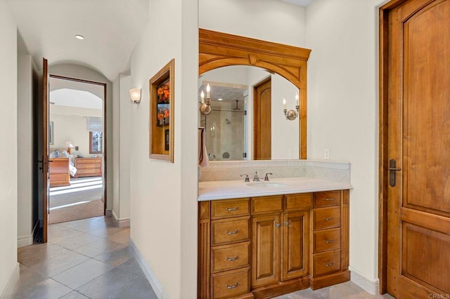 bathroom with vanity, a shower with shower door, and tile patterned floors