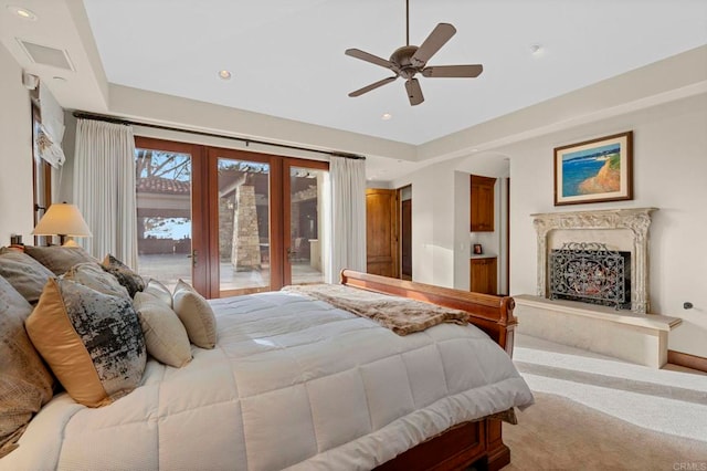 carpeted bedroom featuring french doors, access to exterior, a fireplace, and ceiling fan