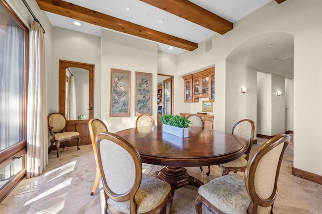 dining space with beamed ceiling