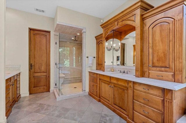 bathroom featuring vanity, tile patterned floors, a chandelier, and a shower with door