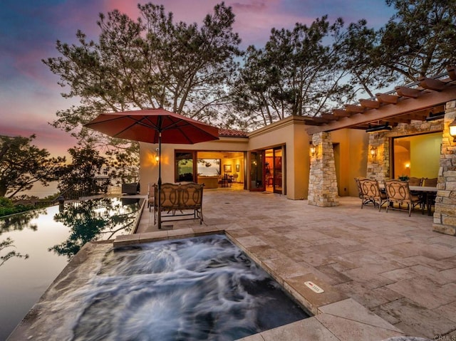 patio terrace at dusk with a hot tub