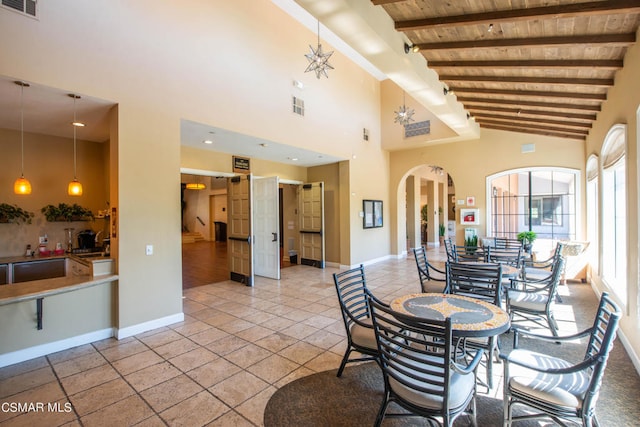 dining space featuring tile floors, high vaulted ceiling, beam ceiling, and wood ceiling