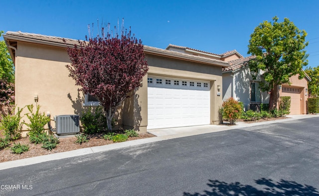 view of front of home featuring a garage and central AC unit