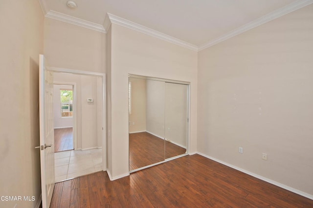 unfurnished bedroom featuring tile flooring, ornamental molding, and a closet