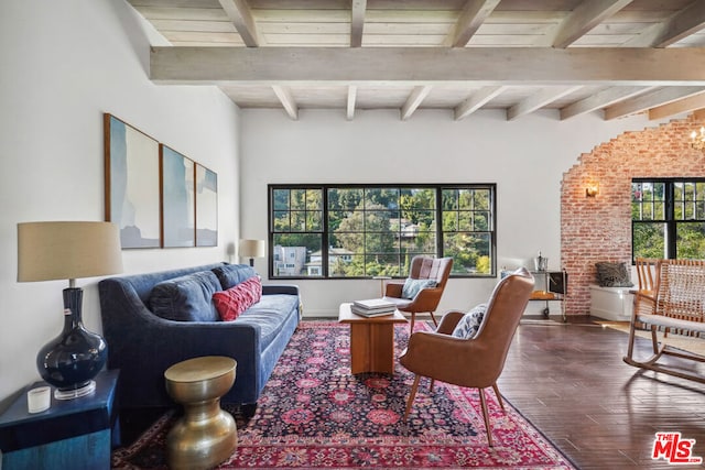 living room with beam ceiling, brick wall, and hardwood / wood-style floors