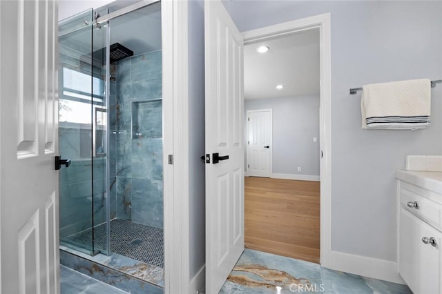 bathroom with wood-type flooring, vanity, and walk in shower