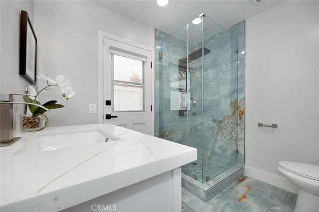 bathroom with tile patterned floors, vanity, a shower with shower door, and toilet