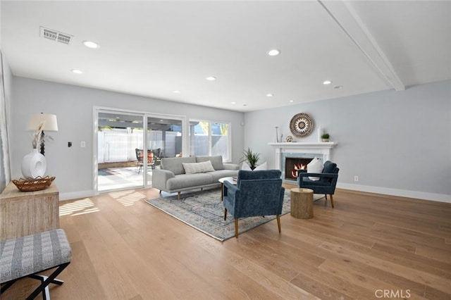 living room with beam ceiling and light hardwood / wood-style flooring