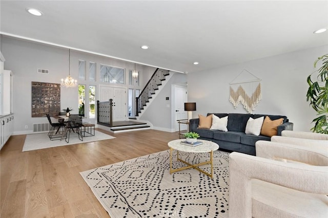 living room with light hardwood / wood-style floors and an inviting chandelier