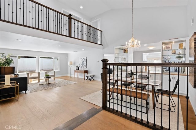 interior space featuring hardwood / wood-style floors, high vaulted ceiling, and an inviting chandelier