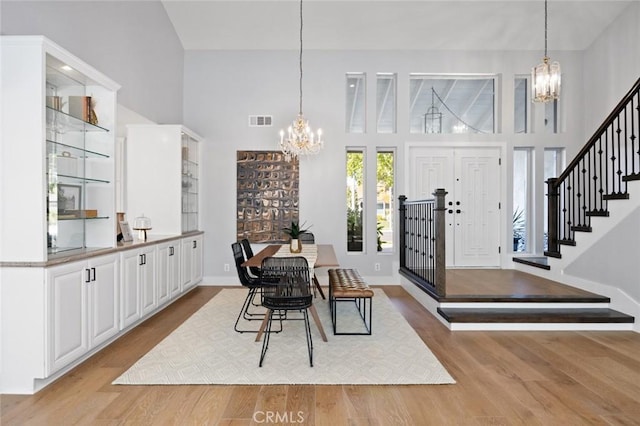 dining area with light hardwood / wood-style floors and a high ceiling