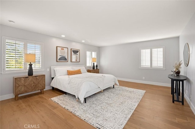 bedroom featuring multiple windows and light wood-type flooring