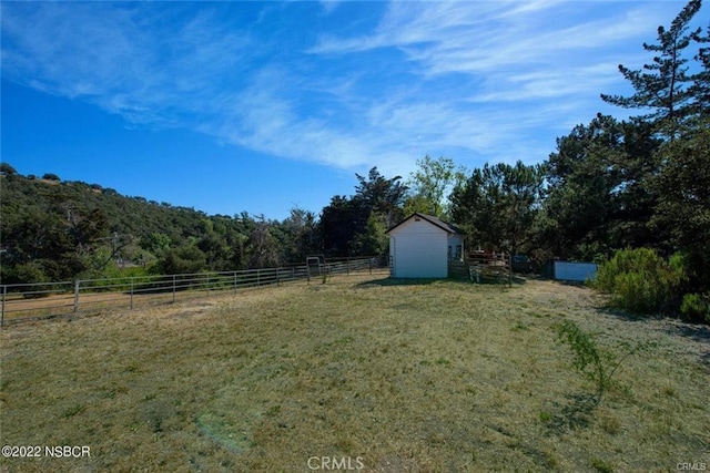 view of yard with a rural view and a storage unit