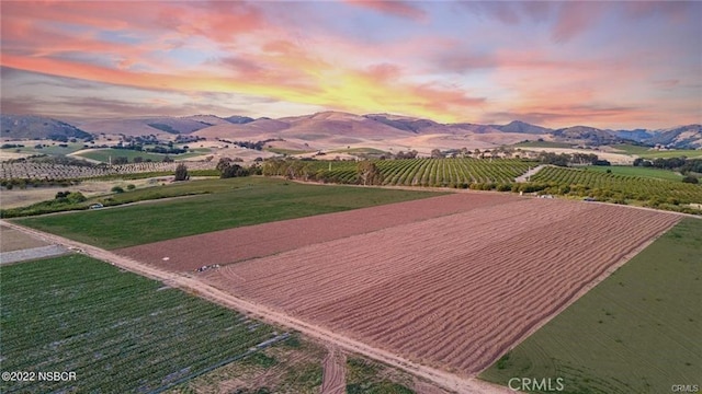 aerial view at dusk with a mountain view and a rural view