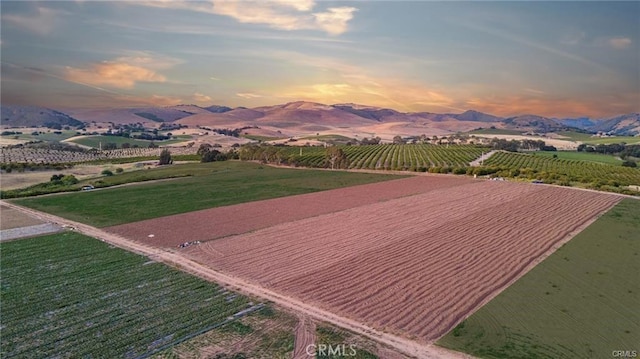 aerial view at dusk featuring a mountain view and a rural view