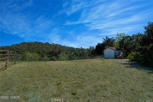 view of yard featuring a rural view and an outdoor structure