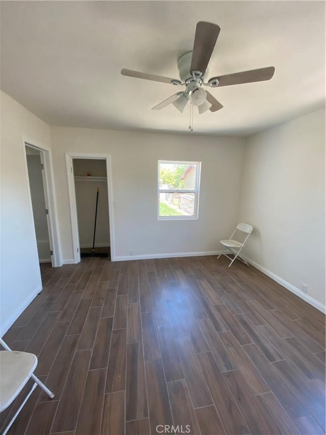 unfurnished room with ceiling fan and dark hardwood / wood-style flooring