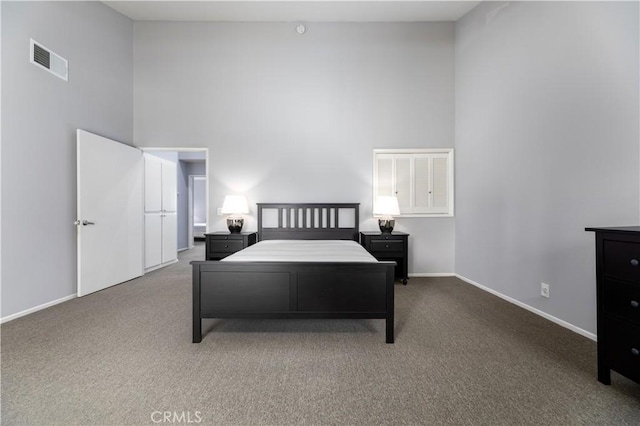 carpeted bedroom with a high ceiling