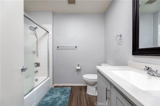 full bathroom with vanity, toilet, combined bath / shower with glass door, and wood-type flooring