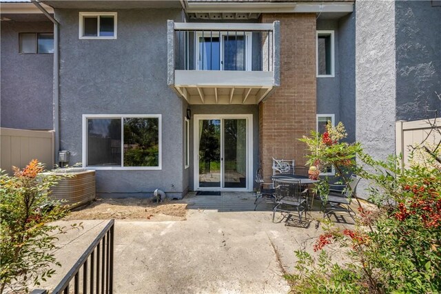 rear view of property featuring a balcony and a patio area