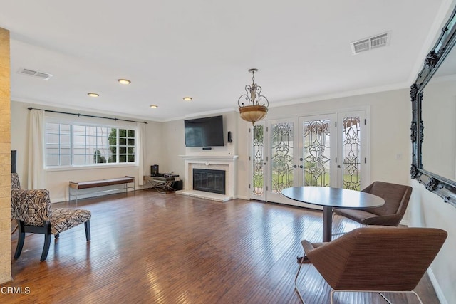 living room featuring crown molding, plenty of natural light, dark hardwood / wood-style flooring, and a premium fireplace