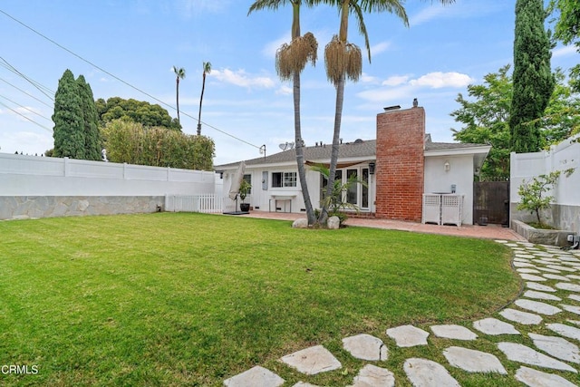 rear view of property featuring a patio area and a lawn