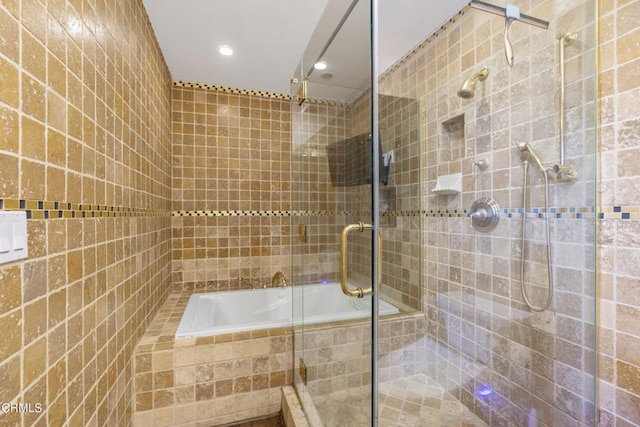 bathroom featuring tile walls and independent shower and bath