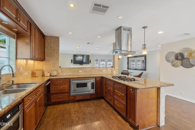 kitchen with stainless steel appliances, hardwood / wood-style flooring, kitchen peninsula, island exhaust hood, and sink