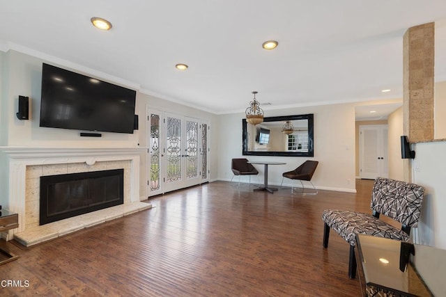 living room featuring crown molding, dark wood-type flooring, and a fireplace