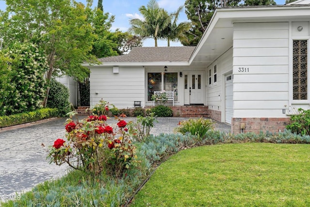 single story home featuring a front lawn and a garage