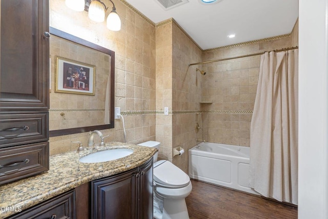 full bathroom featuring tile walls, toilet, shower / bath combination with curtain, wood-type flooring, and vanity