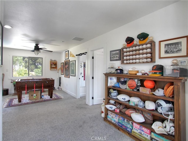 recreation room with ceiling fan and light carpet