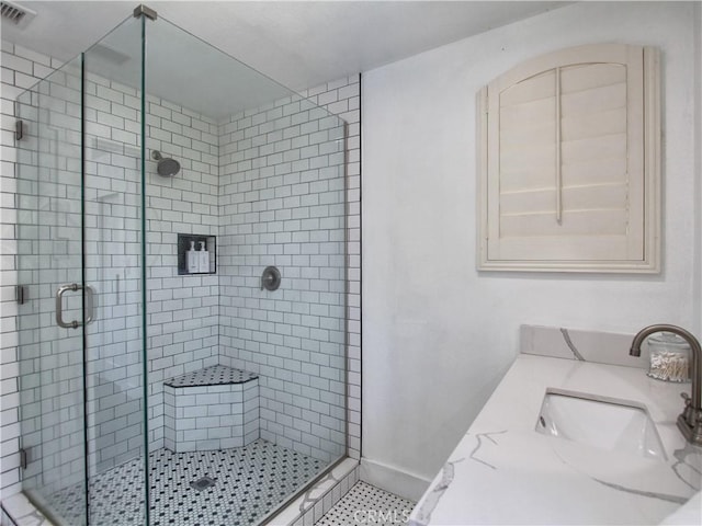 bathroom featuring tile patterned floors, a shower with door, and vanity