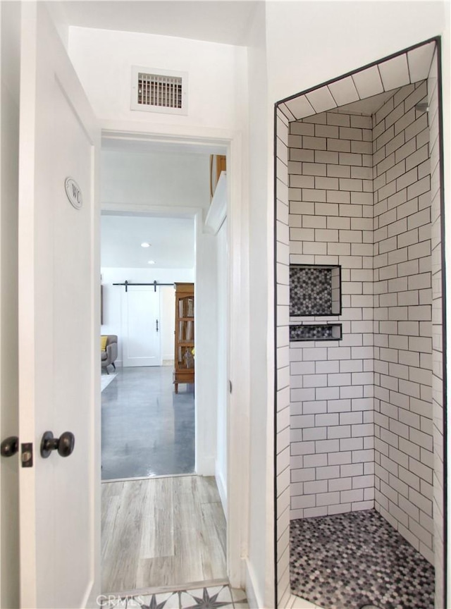 bathroom featuring hardwood / wood-style floors and a tile shower