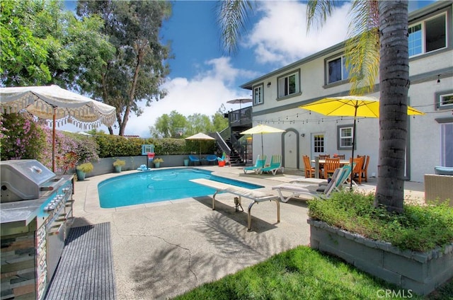 view of swimming pool with a patio area and a diving board