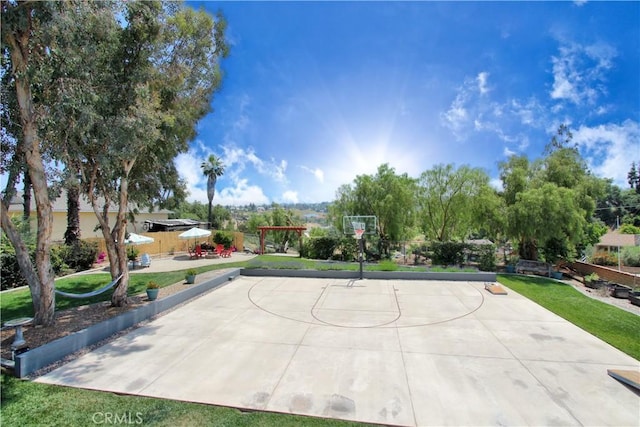 view of basketball court with a yard